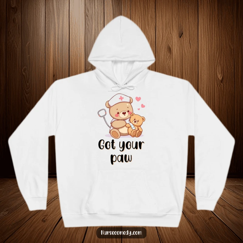 Funny bear nurse hoodie featuring a bear happily bandaging a teddy bear's limb, providing warmth and humorous appreciation for compassionate individuals.